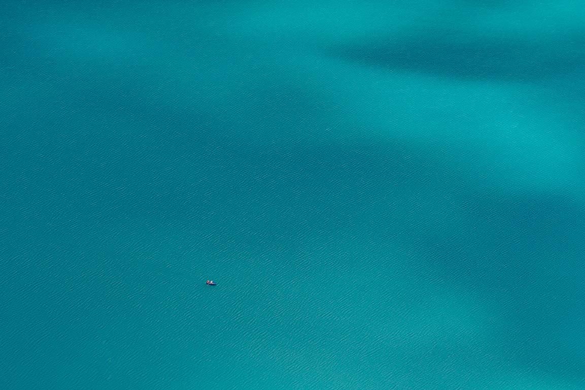 turquiose bergmeer met roeibootje