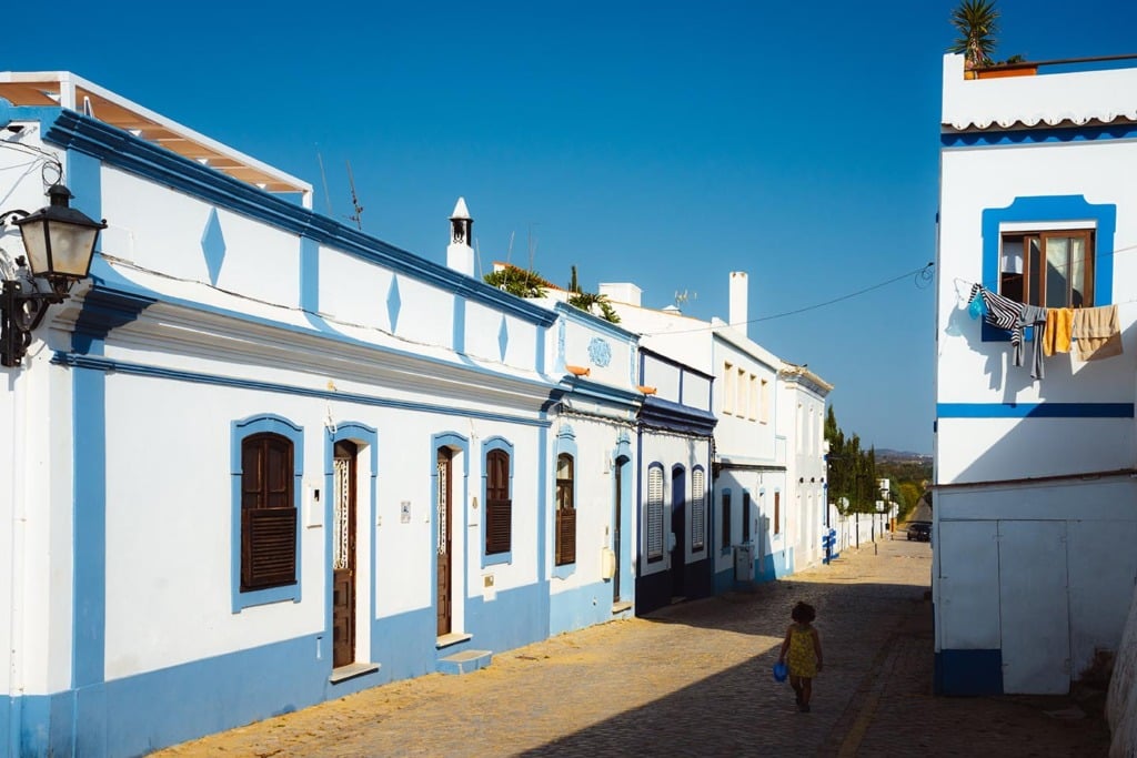 Straat met witgekalkte huizen in dorp in de Algarve