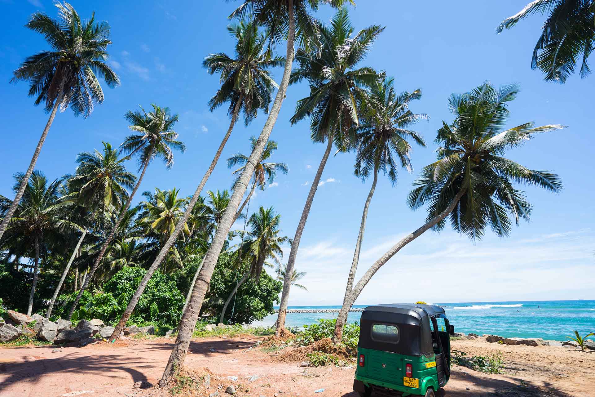 tuktuk onder de palmbomen met uitzicht op zee in Sri Lanka