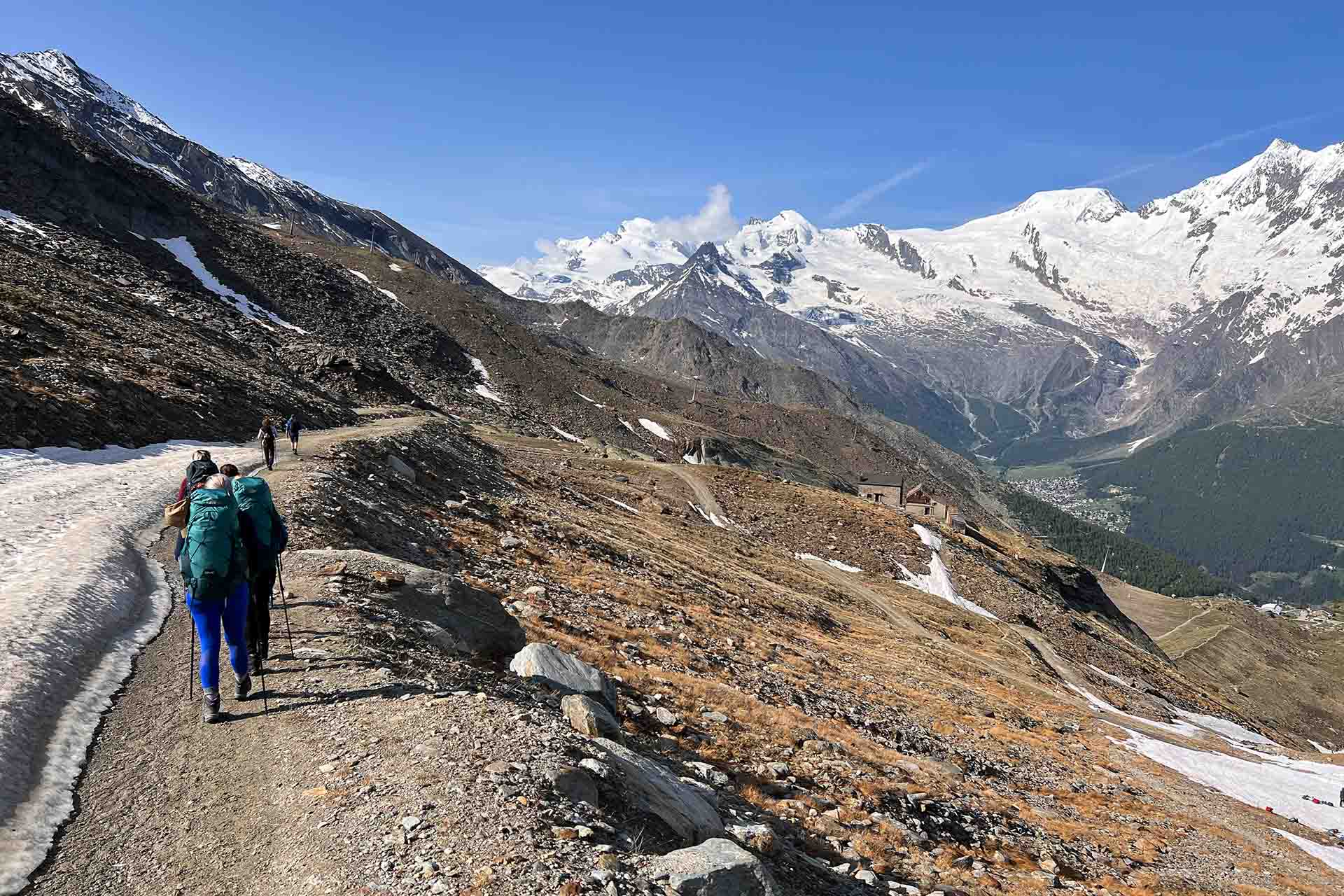 wandelaars met rugzakken en wandelstokken lopen door de besneeuwde bergen in Zwitserland
