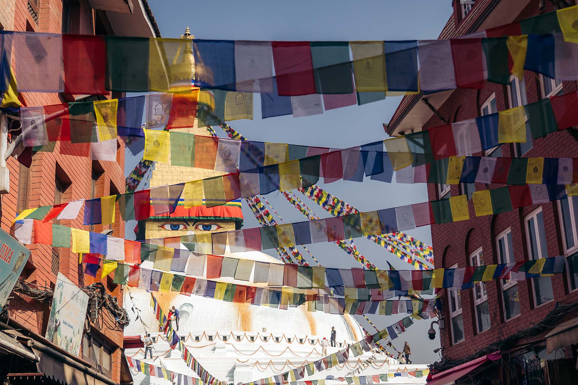 ogen van Boeddha op de Bodnath Stupa in Kathmandu zijn te zien door de gebedsvlaggen