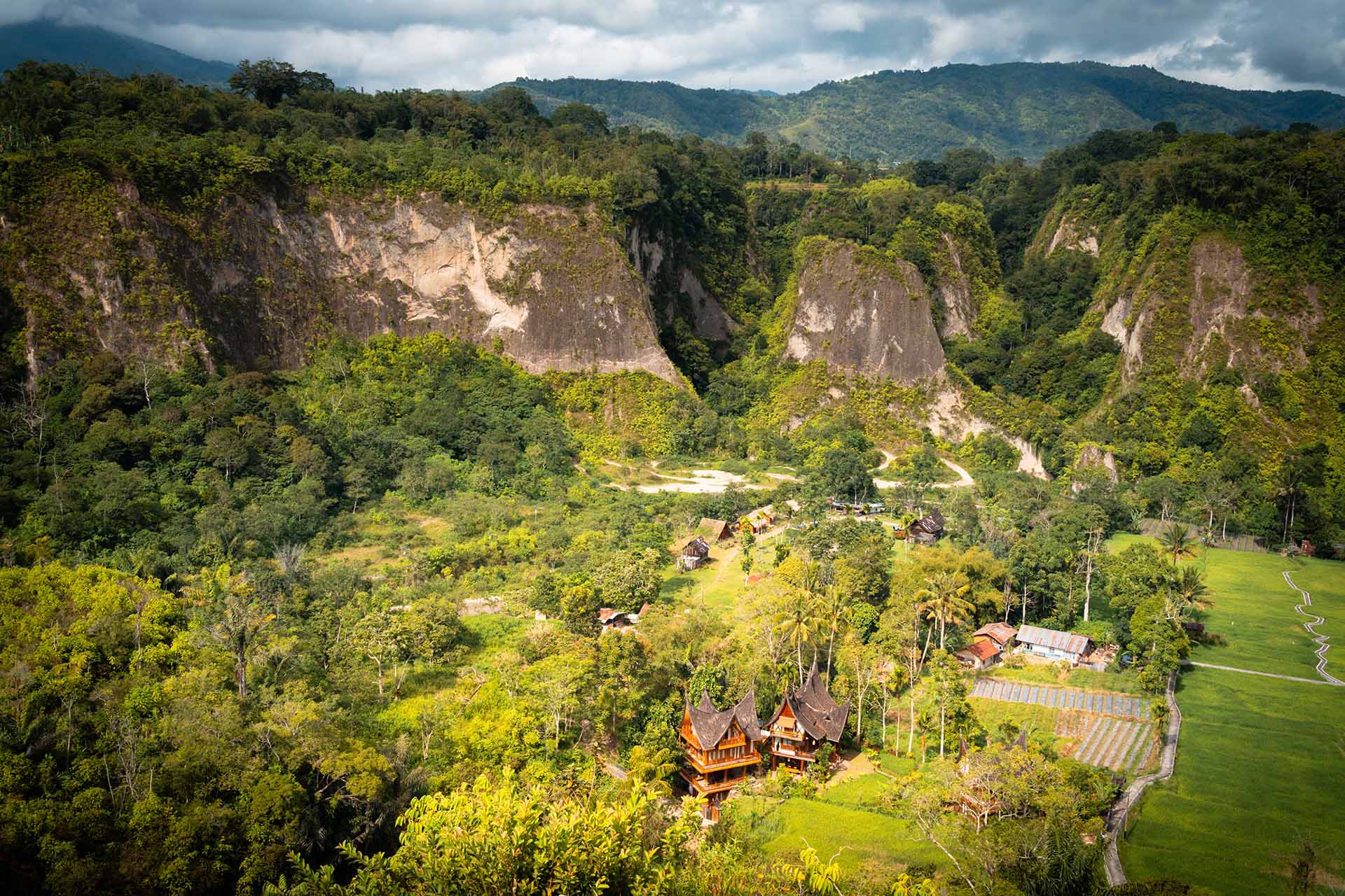 groene vallei omringd door bergen met traditionele huizen Sumatra
