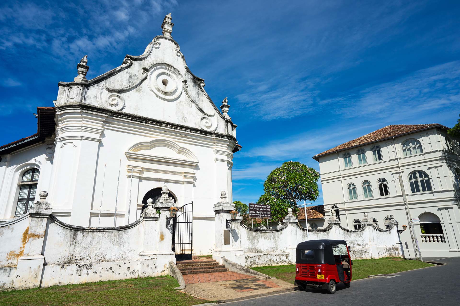 rode tuktuk voor een witte kerk in Galle Sri Lanka