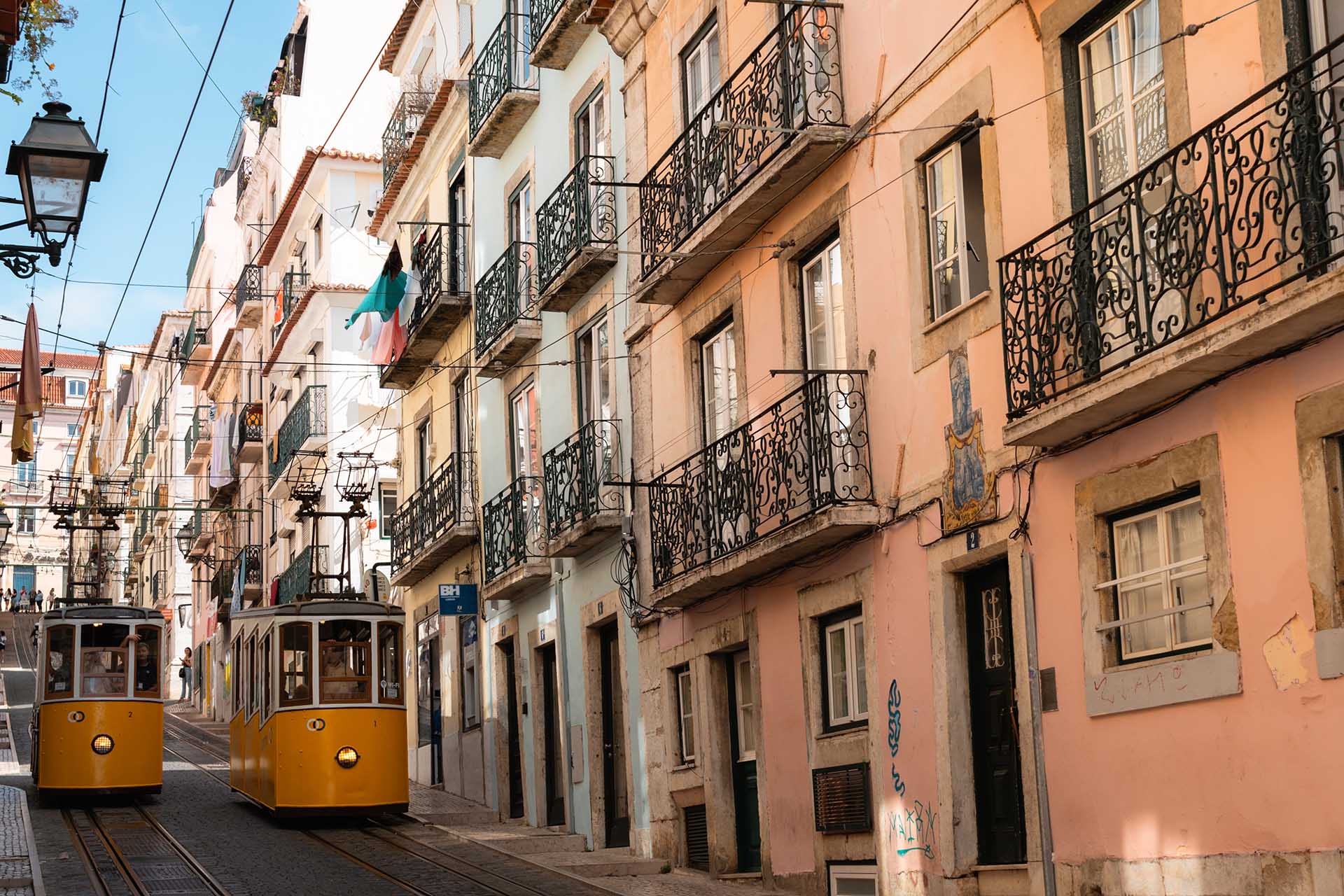 twee trams passeren elkaar in smalle straat in Lissabon