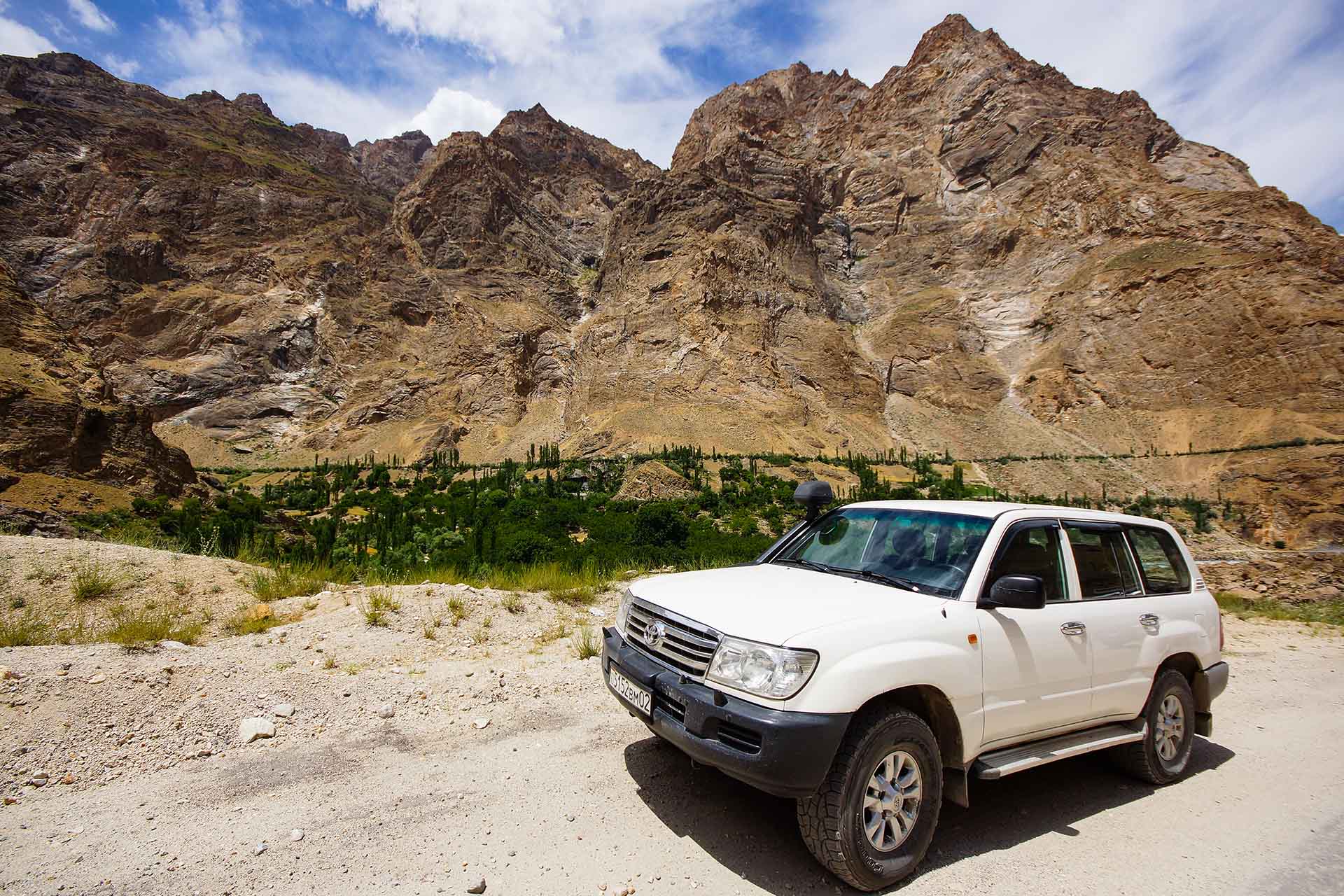 witte jeep bij de bergen in Tadzjikistan