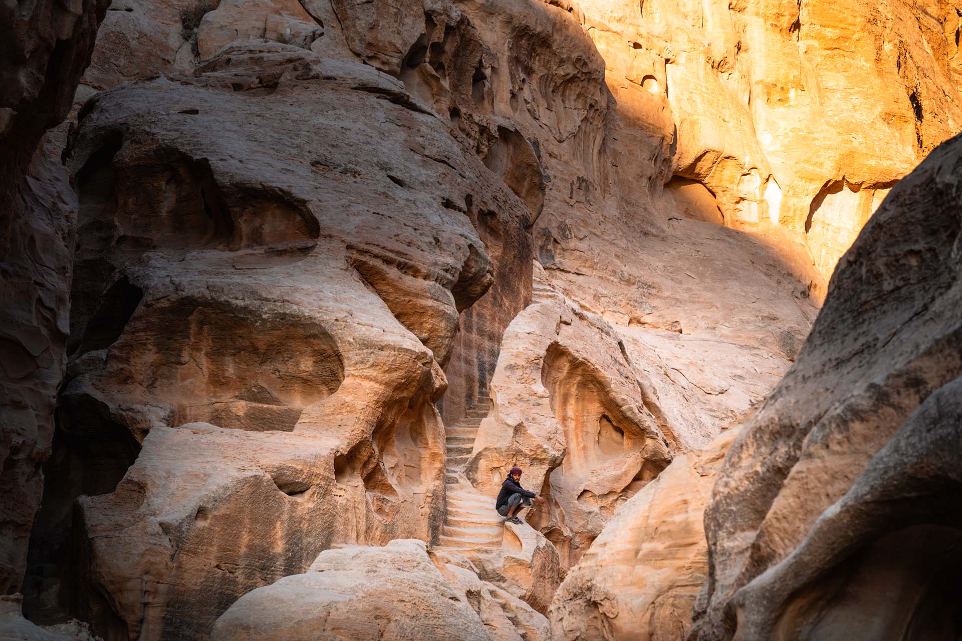 Bedoeïen op hurken tussen rotsen Little Petra