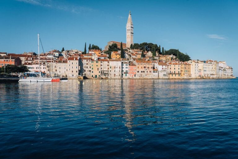 zicht op Rovinj met kerktoren en weerspiegeling in het water