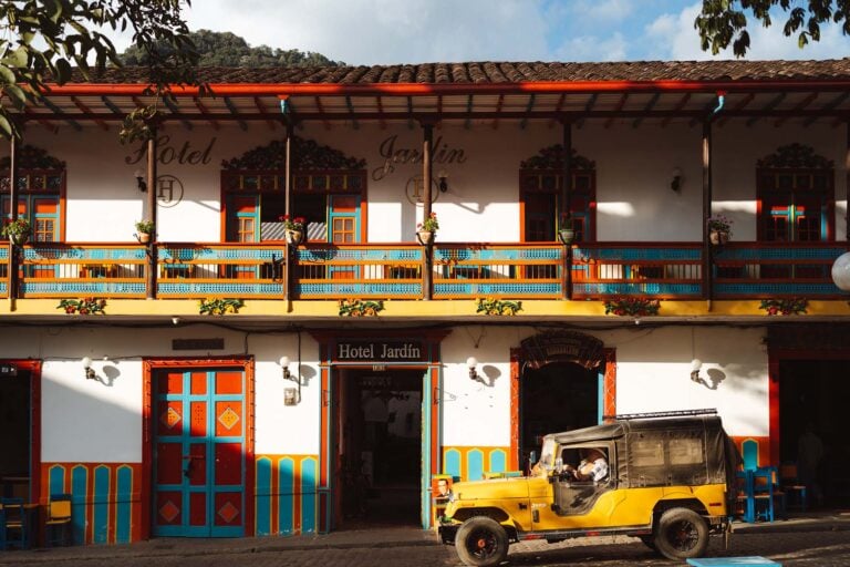 gekleurde huizen met gele jeep