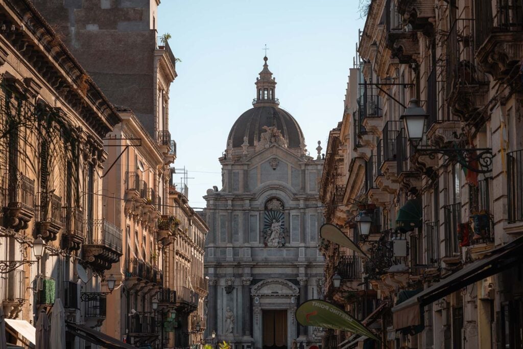 smalle straat met een kerk aan het einde in Catania