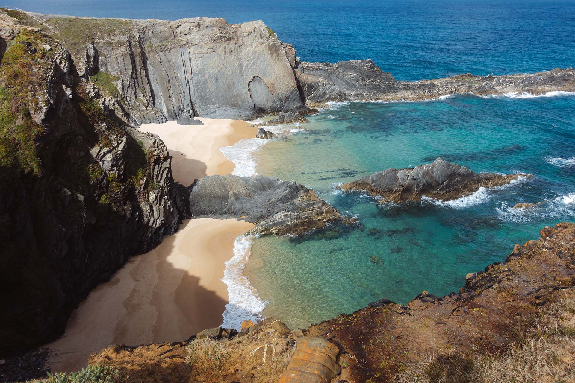 baai met twee stranden, gescheiden door rotspartij