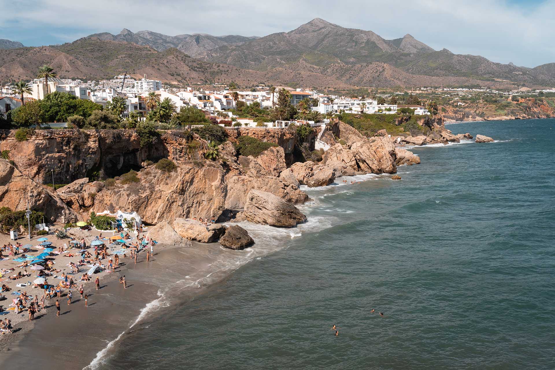 strand met rotsen en bergen erachter