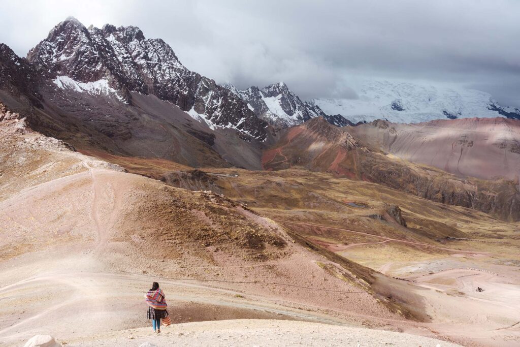 Peruviaanse vrouw in landschap Rainbow Mountain