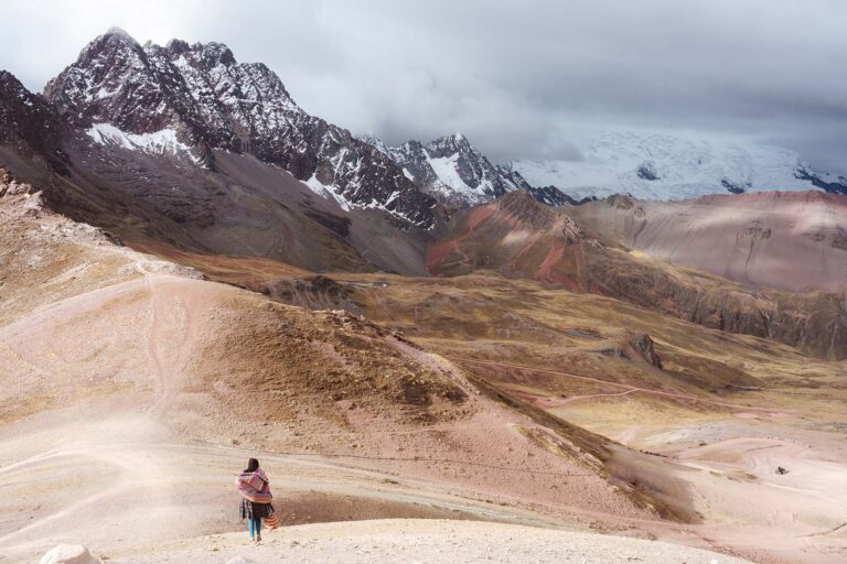 Peruviaanse vrouw in landschap Rainbow Mountain