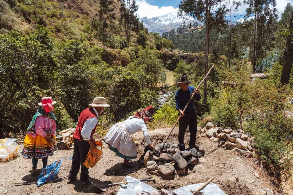 lokale bewoners vullen oven voor pachamanca-ritueel